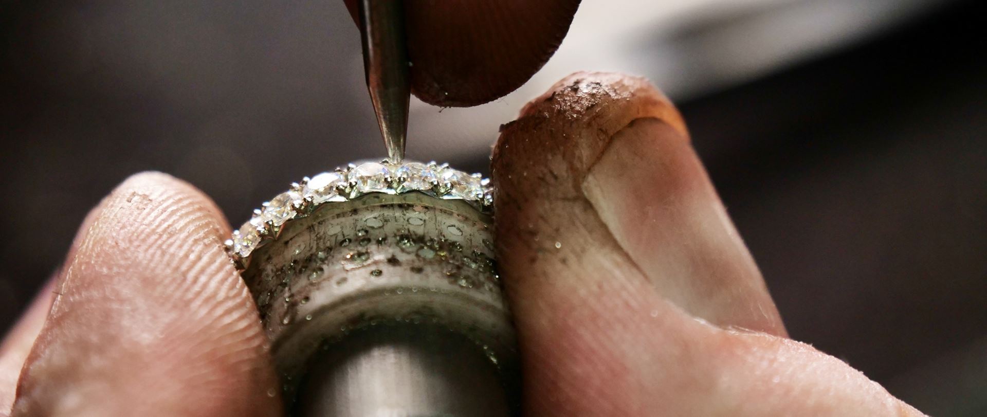 Alliansring med flera diamanter under infattning i guldsmedsverkstad – handgjorda ringar i Göteborg
