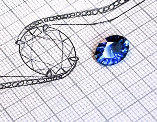 Lös blå safir bredvid enkel skiss som visar hur ädelstenen kan användas i en ring, med fokus på färg, form och hantverksprocess.