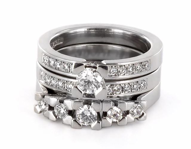 Kombination av trestensring, enstensring med sidostenar och matchande alliansring i vitguld, utformade för att fungera tillsammans genom personlig anpassning och hantverk.