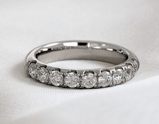 Handtillverkad alliansring i vitguld med nio briljantslipade diamanter i castell-fattning, utformad för komfort, balans och lång hållbarhet.